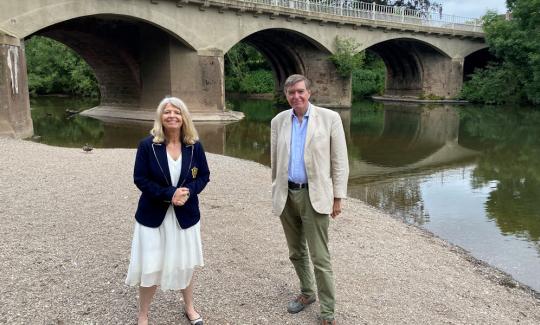 Harriett Baldwin MP and Philip Dunne MP discuss local services at the boundary of Worcestershire and Shropshire at the river Teme.